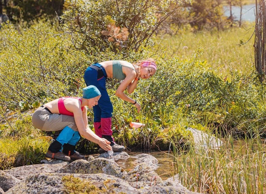 Dvě ženy využívající vodu z řeky pro každodenní hygienu